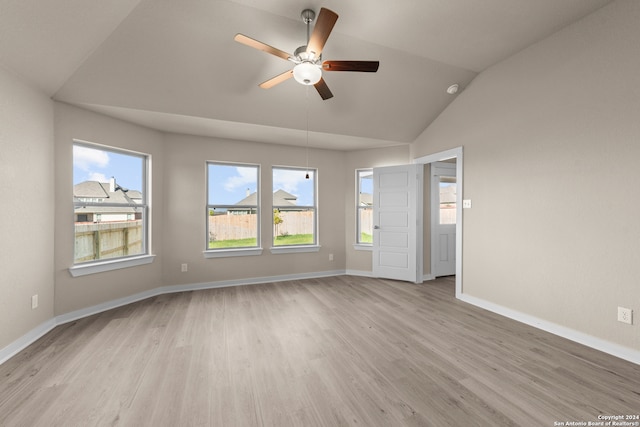 empty room with ceiling fan, lofted ceiling, and light wood-type flooring