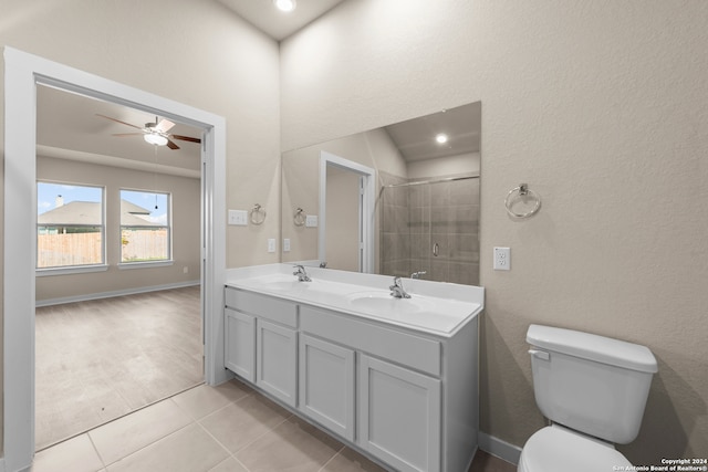 bathroom featuring tile patterned floors, ceiling fan, tiled shower, toilet, and vanity