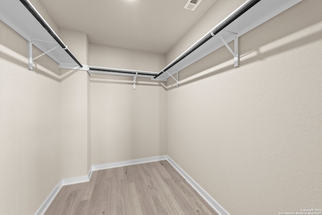 walk in closet with light hardwood / wood-style flooring