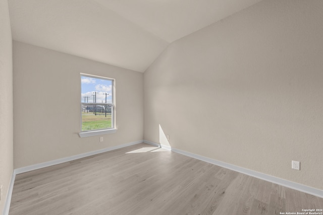 empty room with lofted ceiling and light wood-type flooring