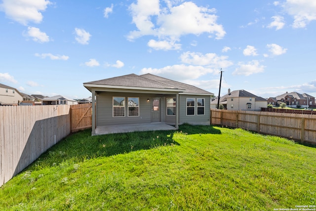 back of house featuring a patio and a lawn