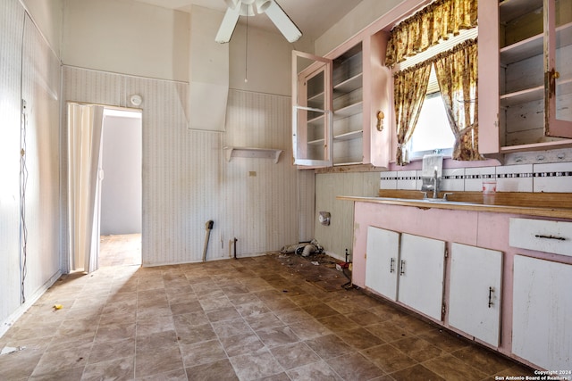 kitchen with light tile floors, ceiling fan, and white cabinets