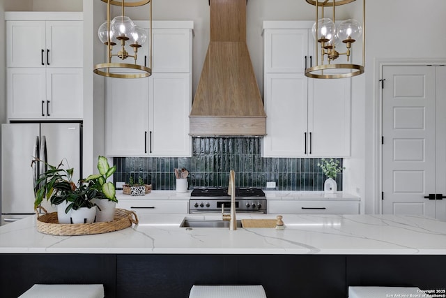 8214 Sierra Hermosa, San Antonio, TX 78255 - kitchen with premium range hood, stainless steel appliances, hanging light fixtures, and decorative backsplash