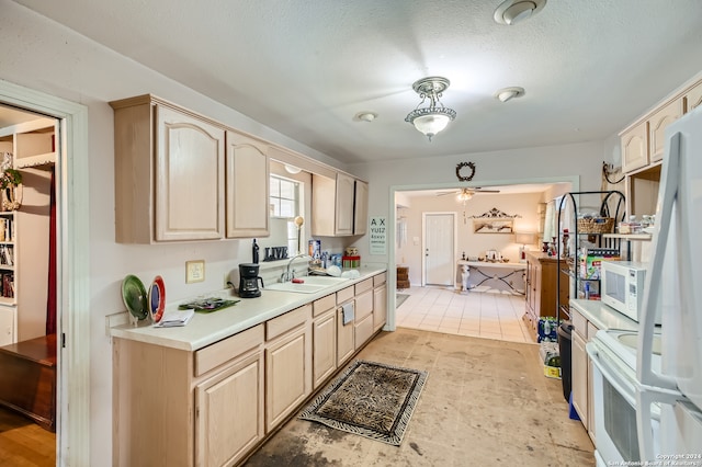 kitchen with light brown cabinetry, ceiling fan, white appliances, light tile floors, and sink