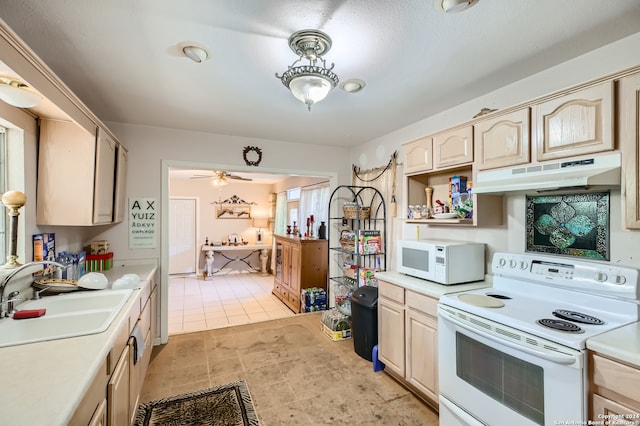 kitchen with light brown cabinets, light tile floors, ceiling fan, white appliances, and sink