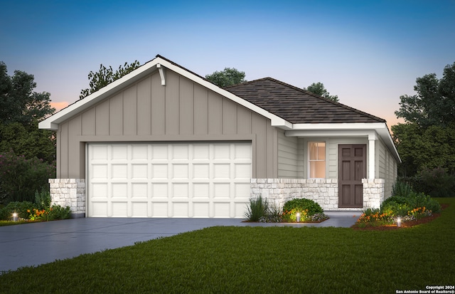 view of front of property featuring a garage and a lawn