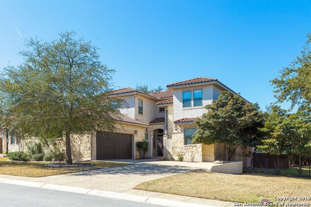 mediterranean / spanish house with a front yard and a garage