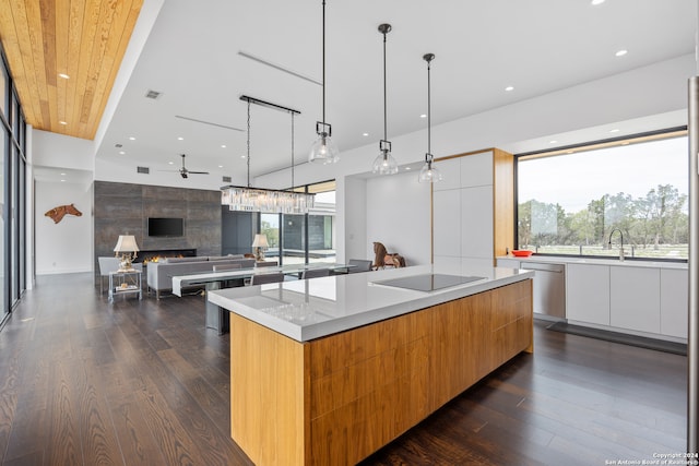 kitchen with hanging light fixtures, a large island, a fireplace, and black electric cooktop