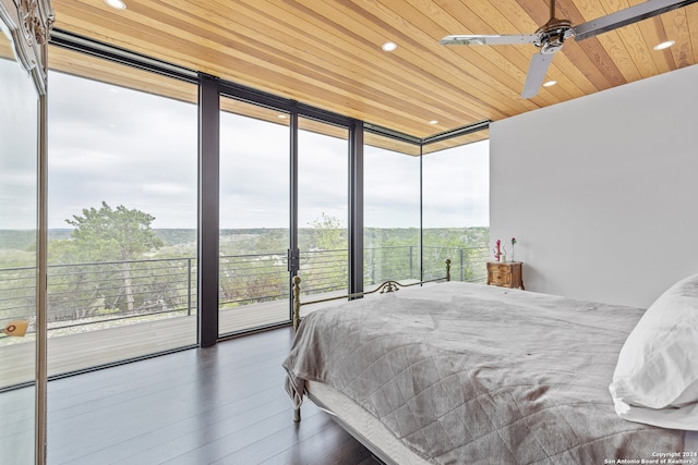 bedroom featuring dark hardwood / wood-style flooring, ceiling fan, multiple windows, and access to outside