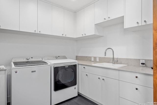 laundry room featuring cabinets, washing machine and dryer, and sink