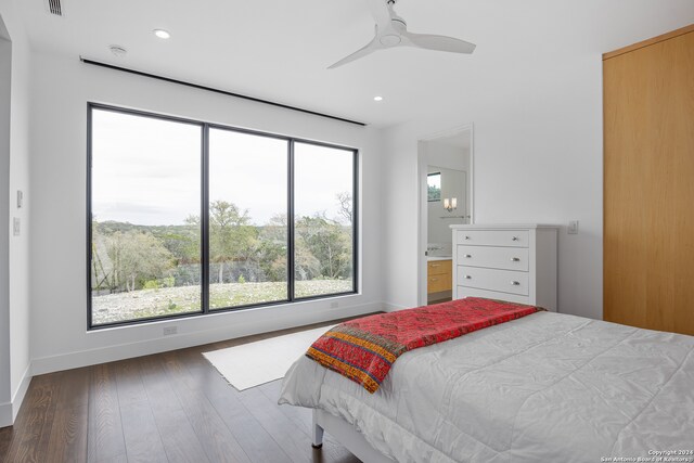 bedroom with dark wood-type flooring, ceiling fan, and connected bathroom