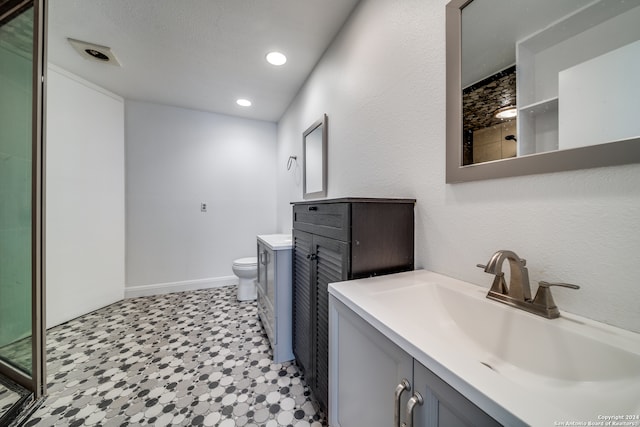 bathroom with tile flooring, oversized vanity, and toilet