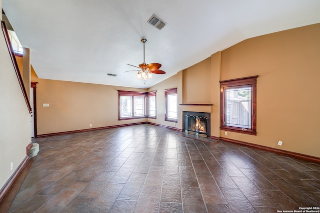 unfurnished living room featuring lofted ceiling, ceiling fan, and dark tile floors