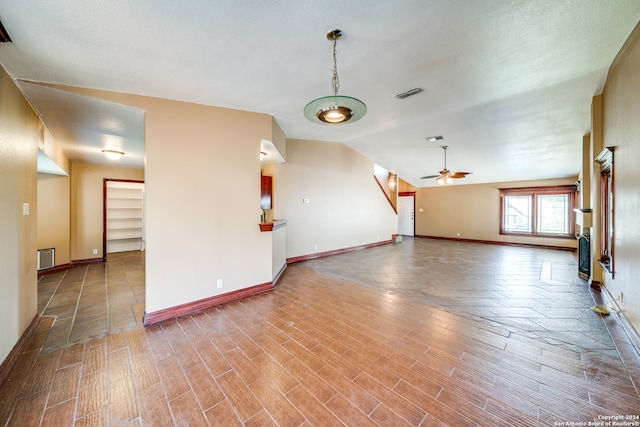 unfurnished living room with ceiling fan and light tile flooring