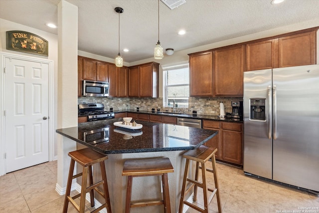 kitchen featuring a center island, tasteful backsplash, appliances with stainless steel finishes, and decorative light fixtures