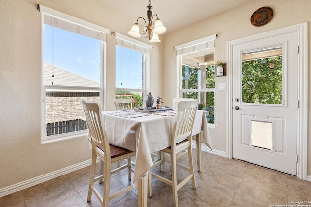 dining room with a notable chandelier and light tile floors