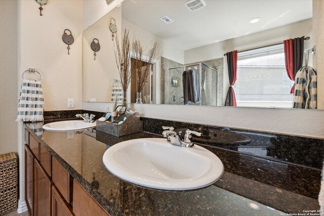 bathroom featuring walk in shower and dual vanity