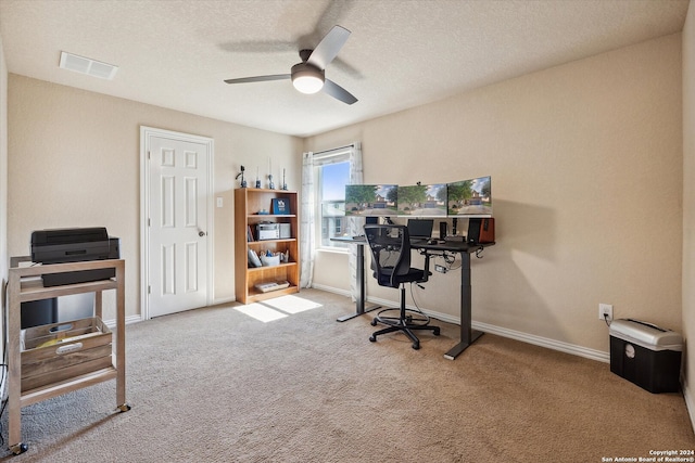 office space with light colored carpet, ceiling fan, and a textured ceiling