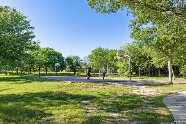 surrounding community with basketball hoop and a yard