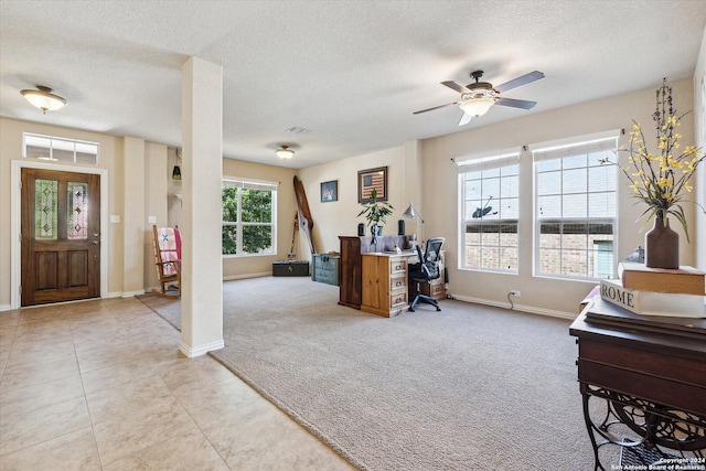 carpeted home office featuring a textured ceiling and ceiling fan