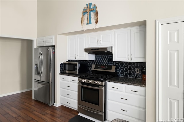 kitchen featuring white cabinets, tasteful backsplash, dark stone counters, stainless steel appliances, and dark hardwood / wood-style floors