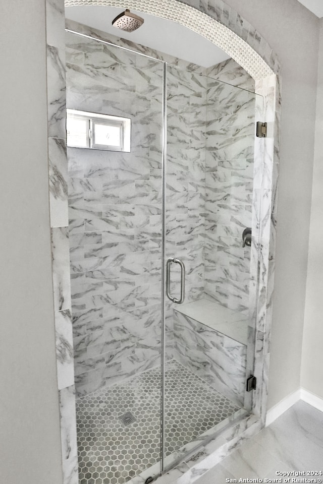 bathroom with an enclosed shower and tile flooring