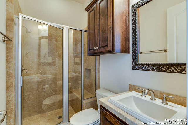 bathroom featuring vanity, toilet, and a shower with door