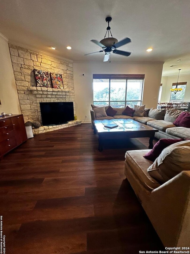 living room featuring hardwood / wood-style floors, ceiling fan, a fireplace, and crown molding