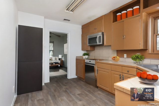 kitchen with light brown cabinetry, tasteful backsplash, hardwood / wood-style flooring, and range