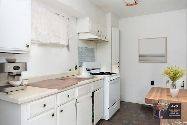 kitchen with white electric stove, dark tile flooring, and white cabinetry