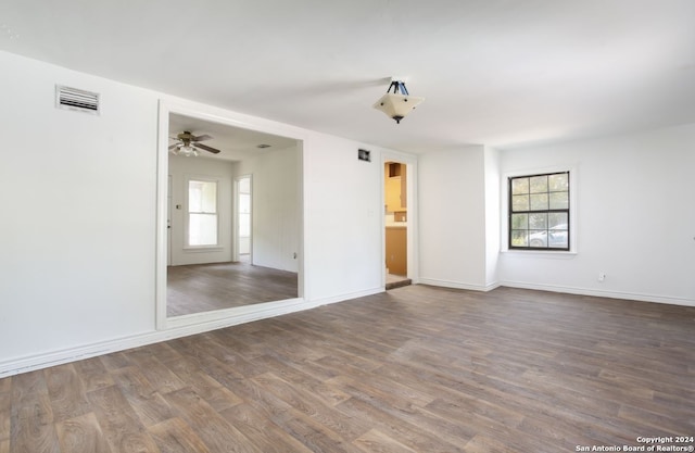 spare room with dark hardwood / wood-style flooring and ceiling fan