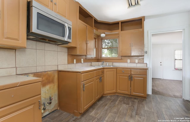 kitchen featuring hardwood / wood-style floors, sink, tile counters, and backsplash