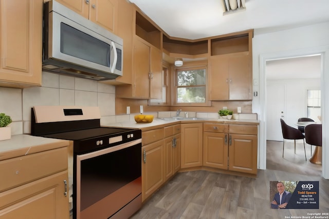 kitchen featuring backsplash, light hardwood / wood-style flooring, electric range oven, light brown cabinetry, and sink