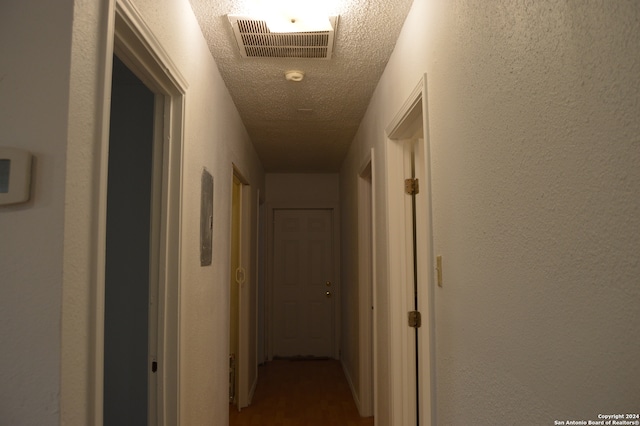 hall with a textured ceiling