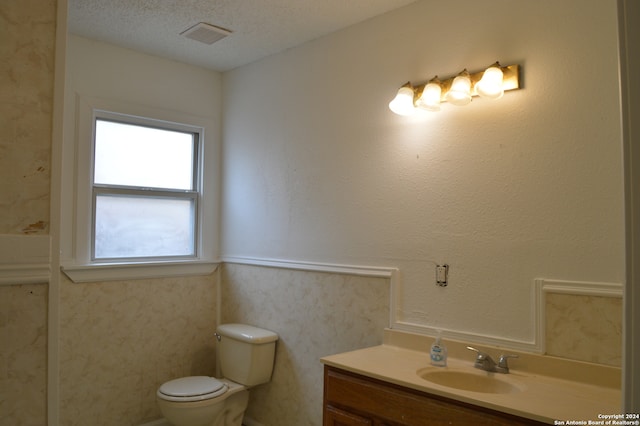 bathroom featuring vanity, toilet, and a textured ceiling