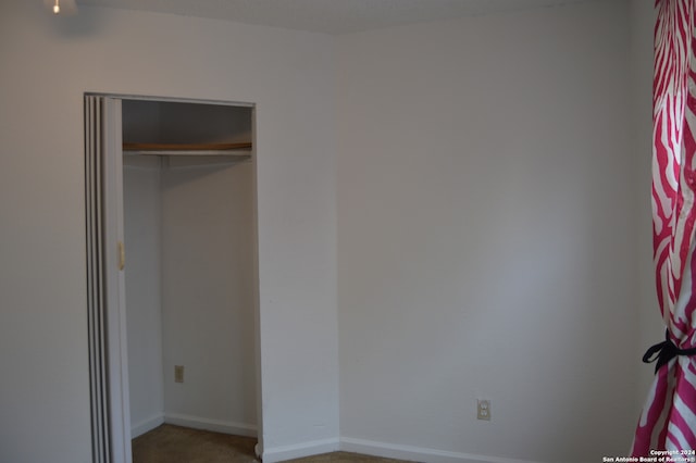 unfurnished bedroom featuring carpet flooring and a closet