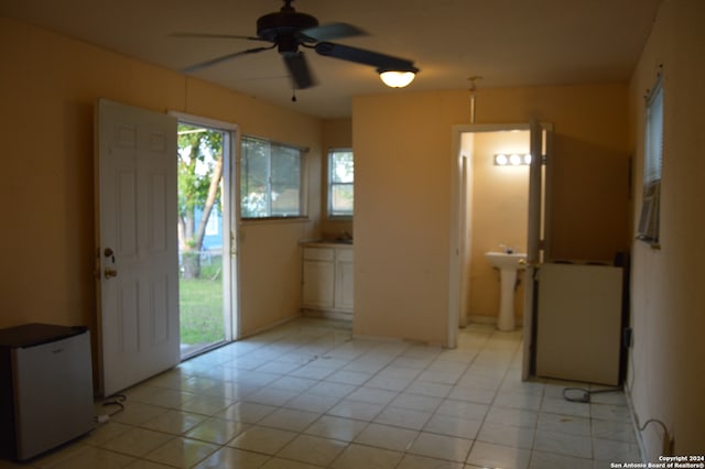 interior space with a healthy amount of sunlight, ceiling fan, and light tile floors