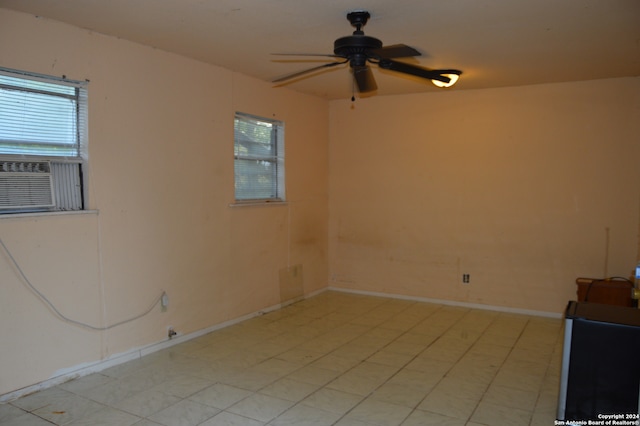 tiled empty room featuring ceiling fan