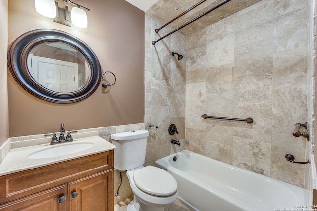 full bathroom featuring vanity with extensive cabinet space, toilet, and tiled shower / bath