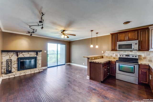 kitchen featuring kitchen peninsula, a stone fireplace, appliances with stainless steel finishes, backsplash, and dark hardwood / wood-style floors