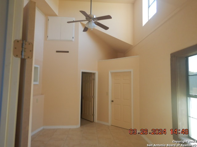 interior space featuring high vaulted ceiling, ceiling fan, and light tile floors