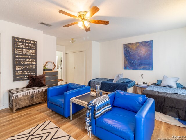 living room featuring light hardwood / wood-style floors and ceiling fan