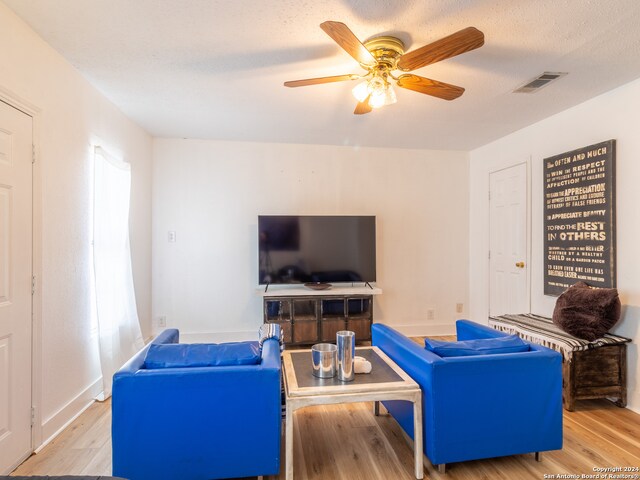 living room featuring light hardwood / wood-style flooring and ceiling fan