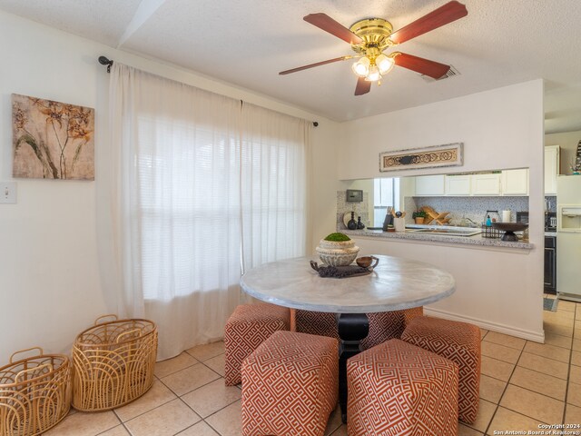 tiled dining space featuring ceiling fan