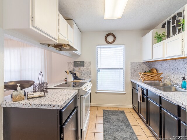 kitchen featuring white cabinets, sink, white electric range oven, and light tile floors