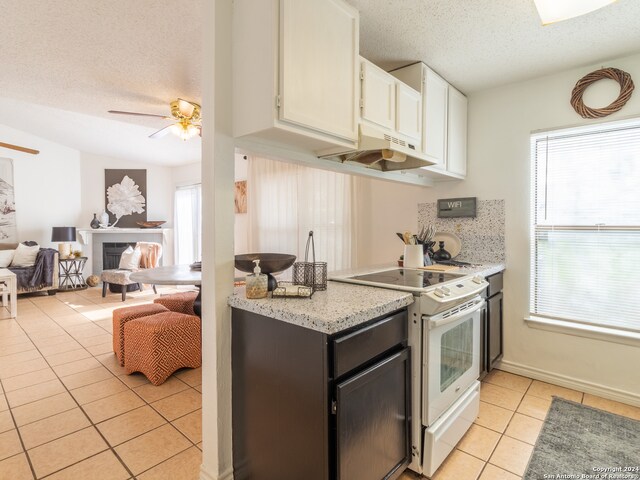 kitchen featuring ceiling fan, a healthy amount of sunlight, white cabinetry, and white range with electric cooktop