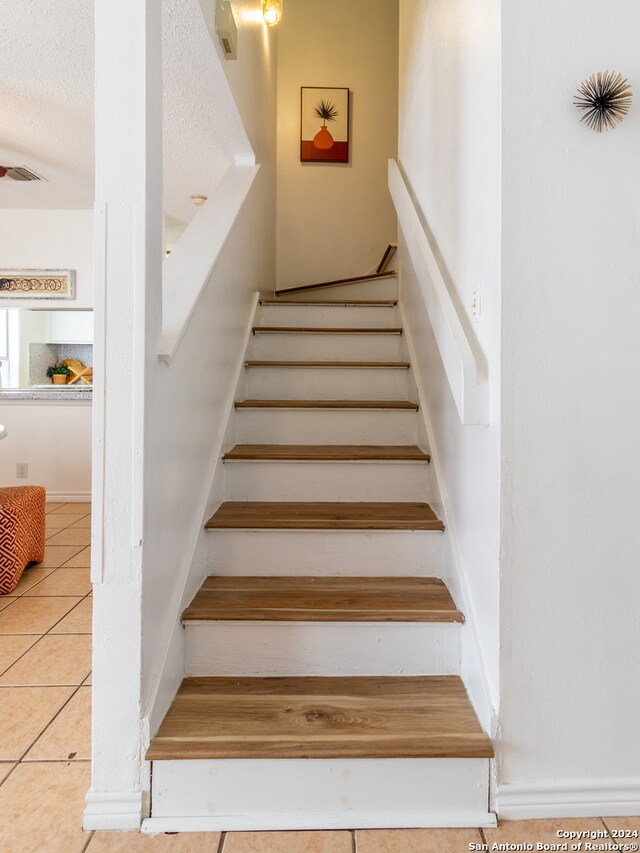 stairs with light tile floors