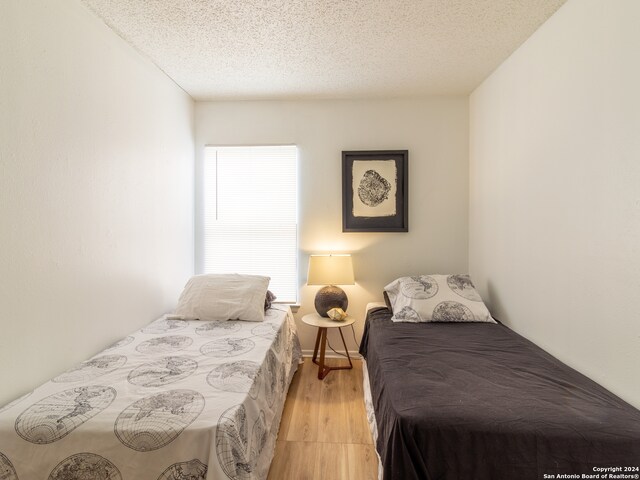 bedroom featuring light wood-type flooring and a textured ceiling