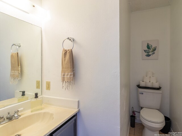 bathroom with vanity, tile floors, and toilet