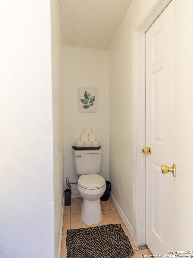 bathroom featuring tile floors and toilet